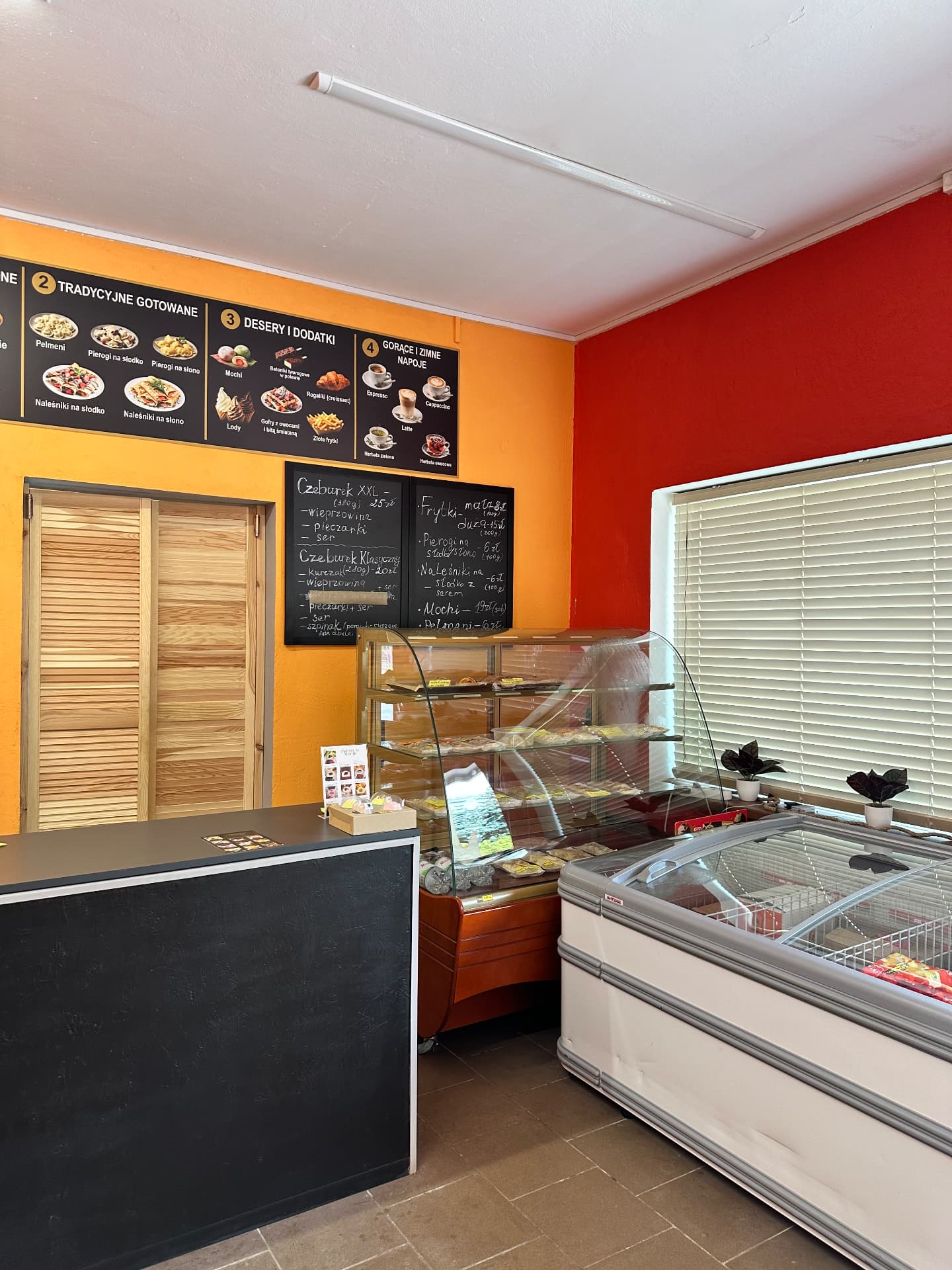 Wnętrze lokalu CHE-SMAK z ladą, witryną i tablicą menu